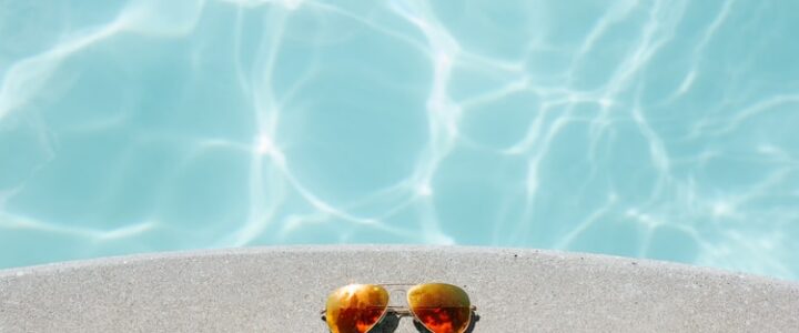 Óculos de sol em uma piscina, em um dia de verão